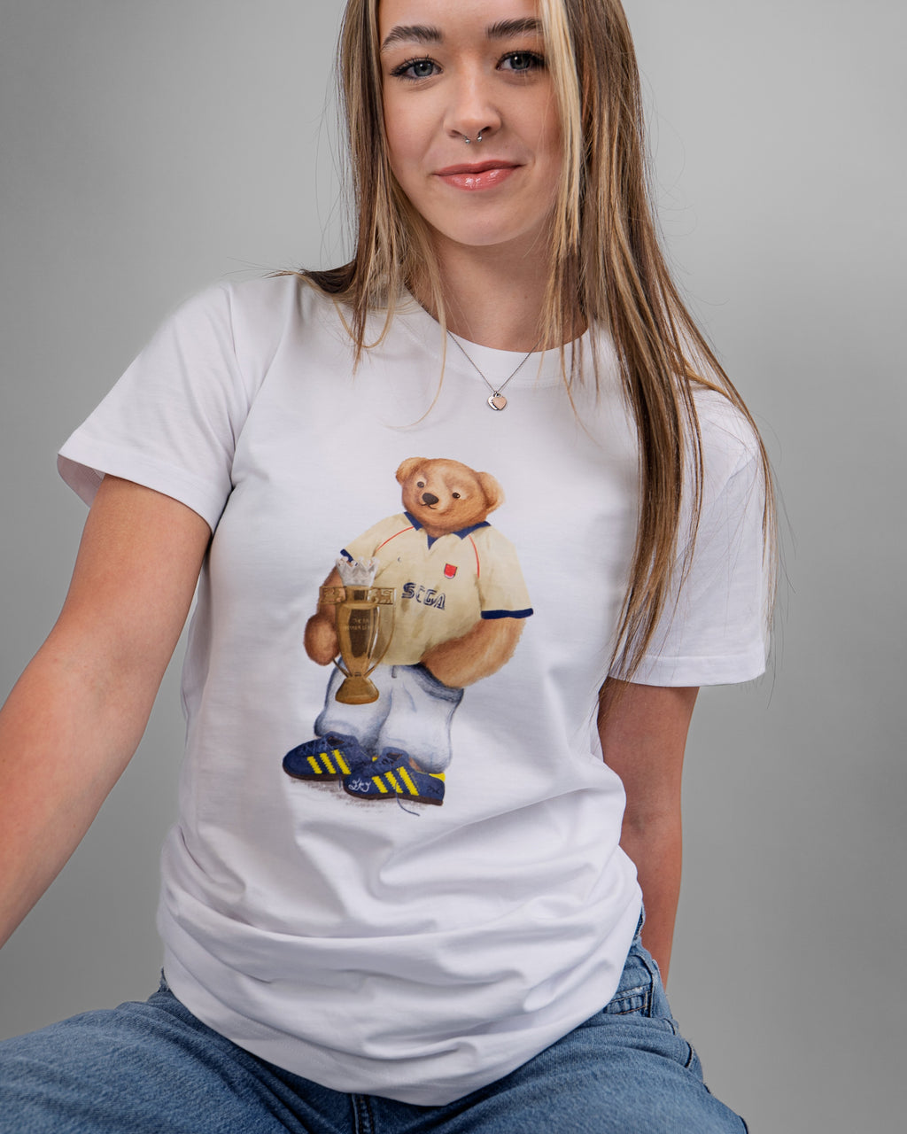 Person wearing a white t-shirt with a graphic of a bear holding a beer mug on a gray background