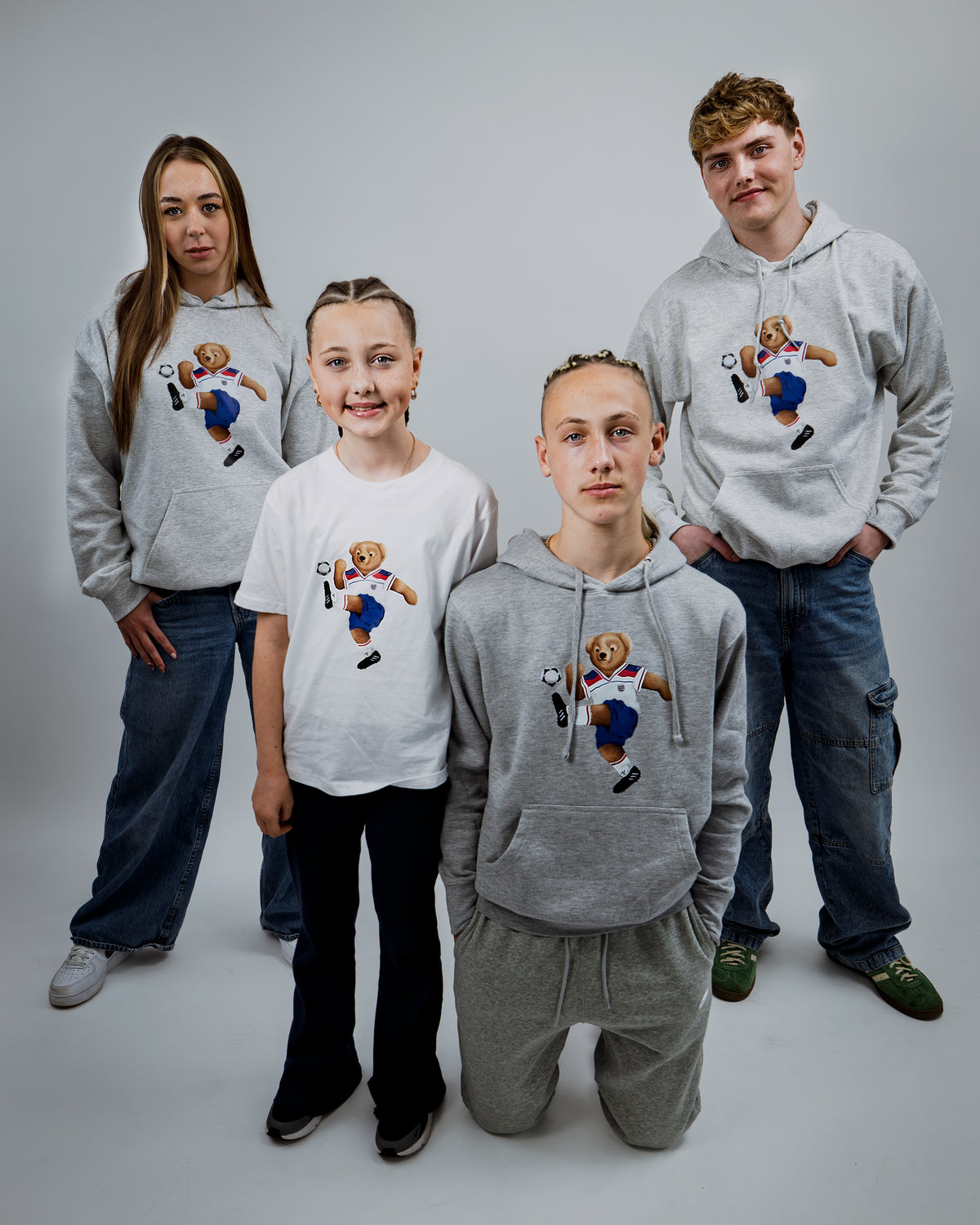 Five people wearing hoodies with a bear graphic design on a plain background