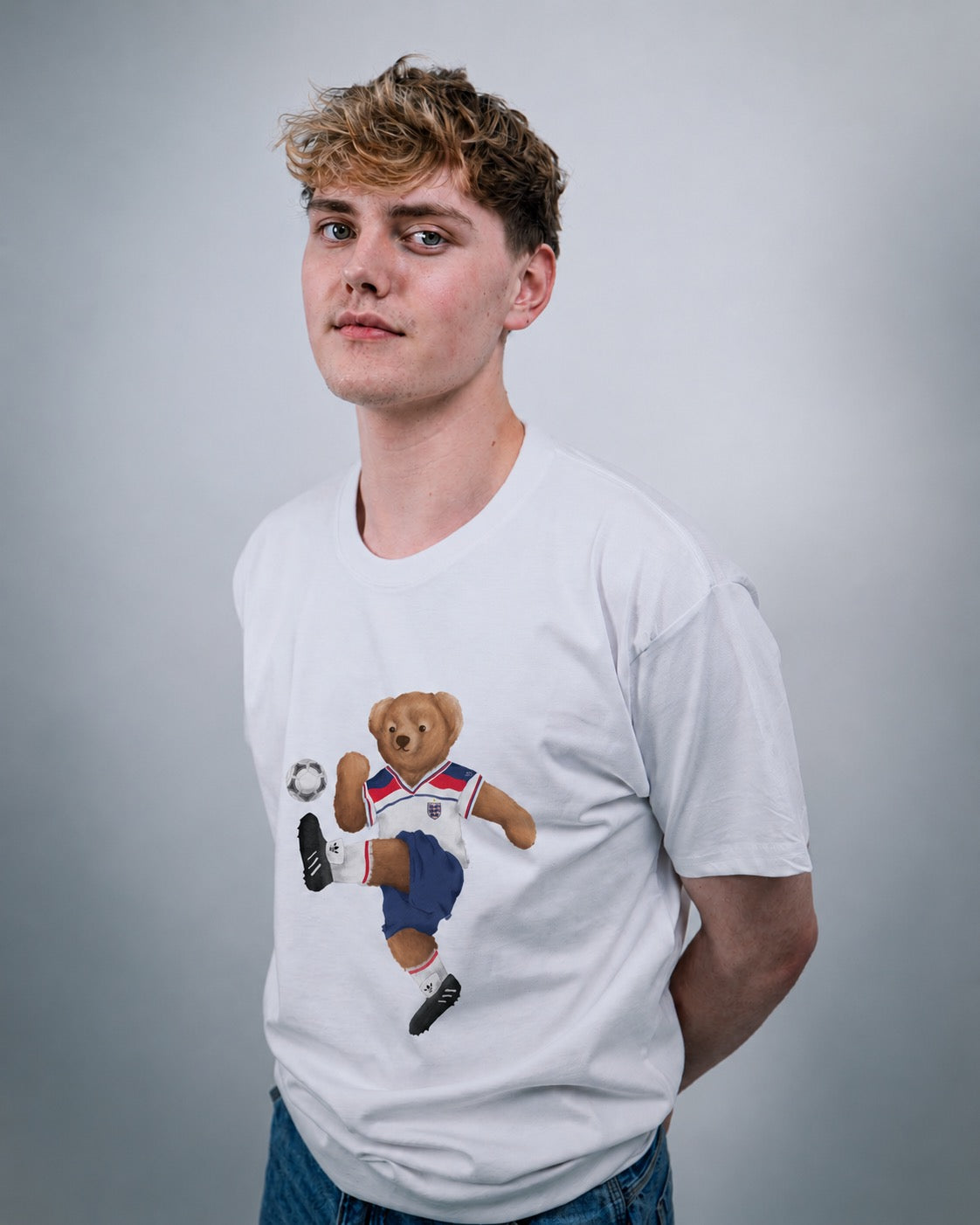 Person wearing a white t-shirt with a bear graphic on a gray background