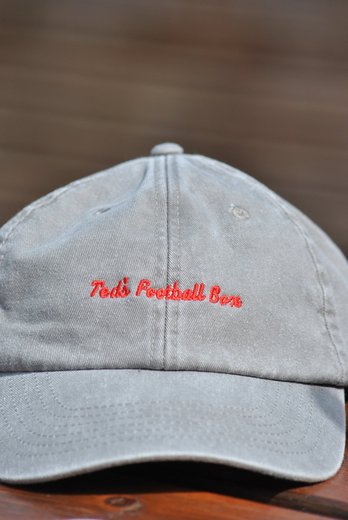 Gray cap with red text on a wooden surface
