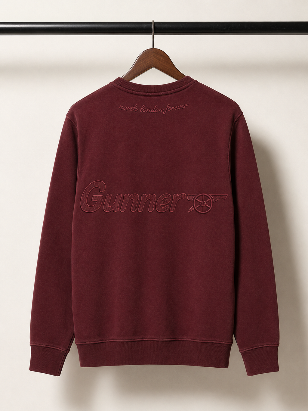 Maroon sweatshirt with 'Gunner' logo on a hanger against a white background