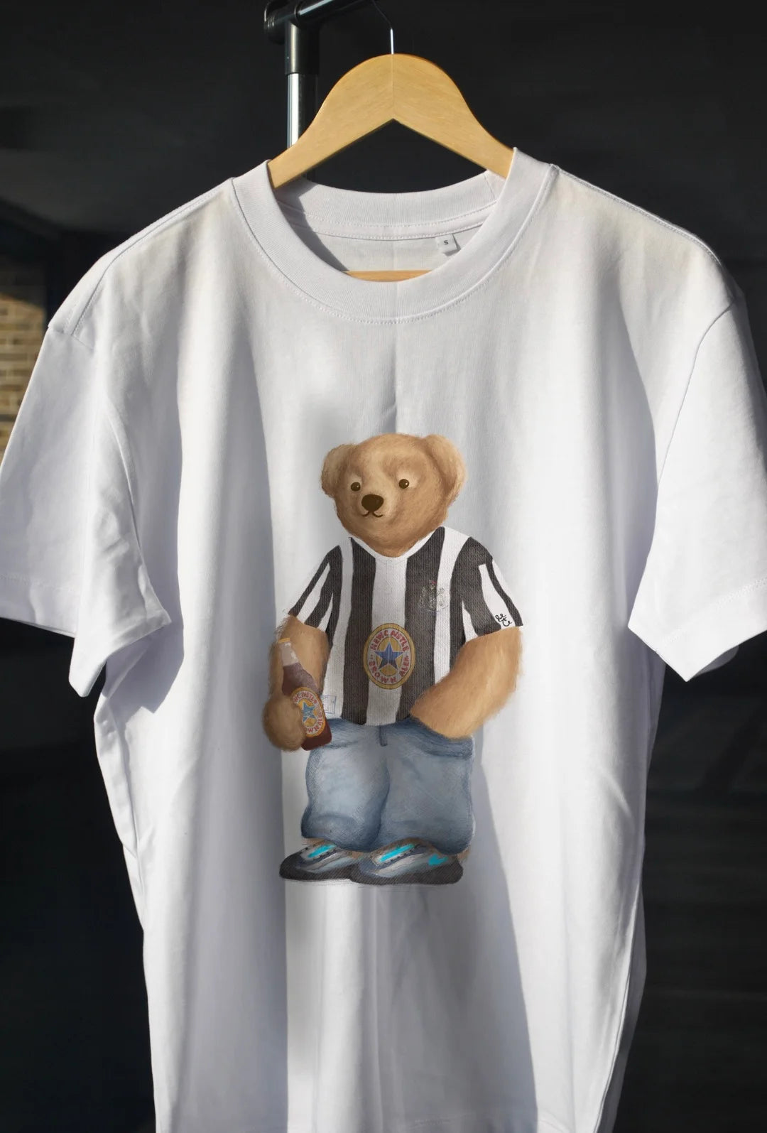 White t-shirt with a graphic of a bear in a Newcastle t shirt
