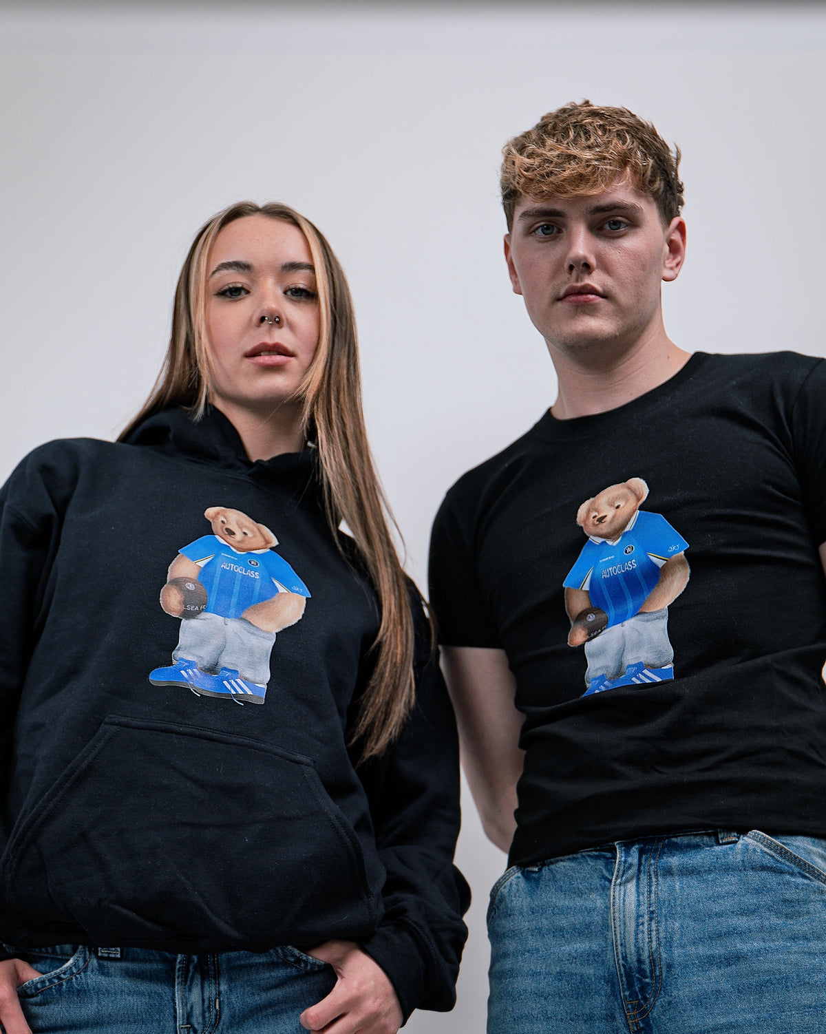 Two people wearing black shirts with a bear graphic design on a plain background