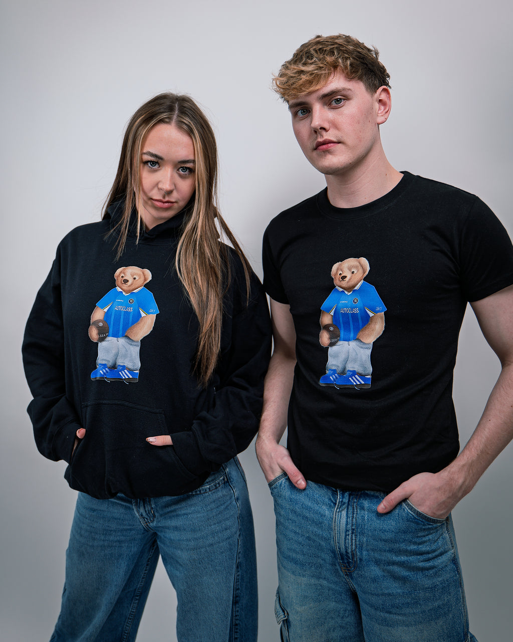 Two people wearing black hoodies and t-shirts with a bear graphic in blue shirts.