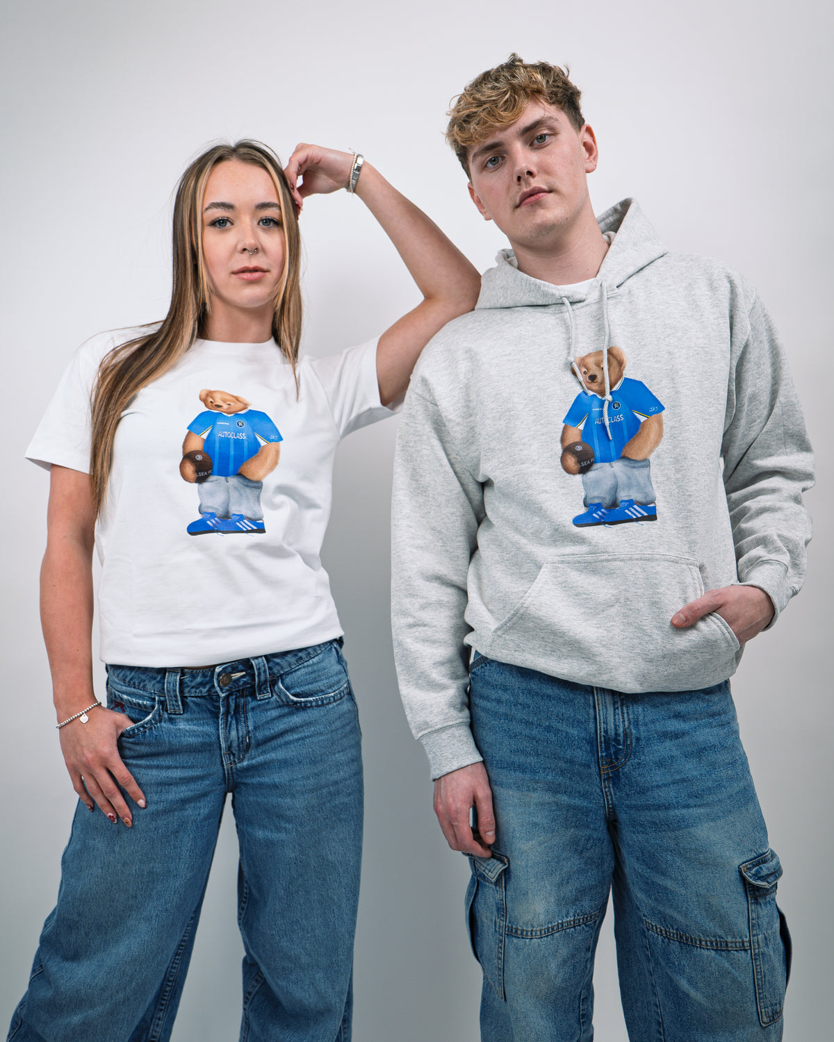 Two people wearing matching hoodies and t-shirts with a bear graphic design on a plain background