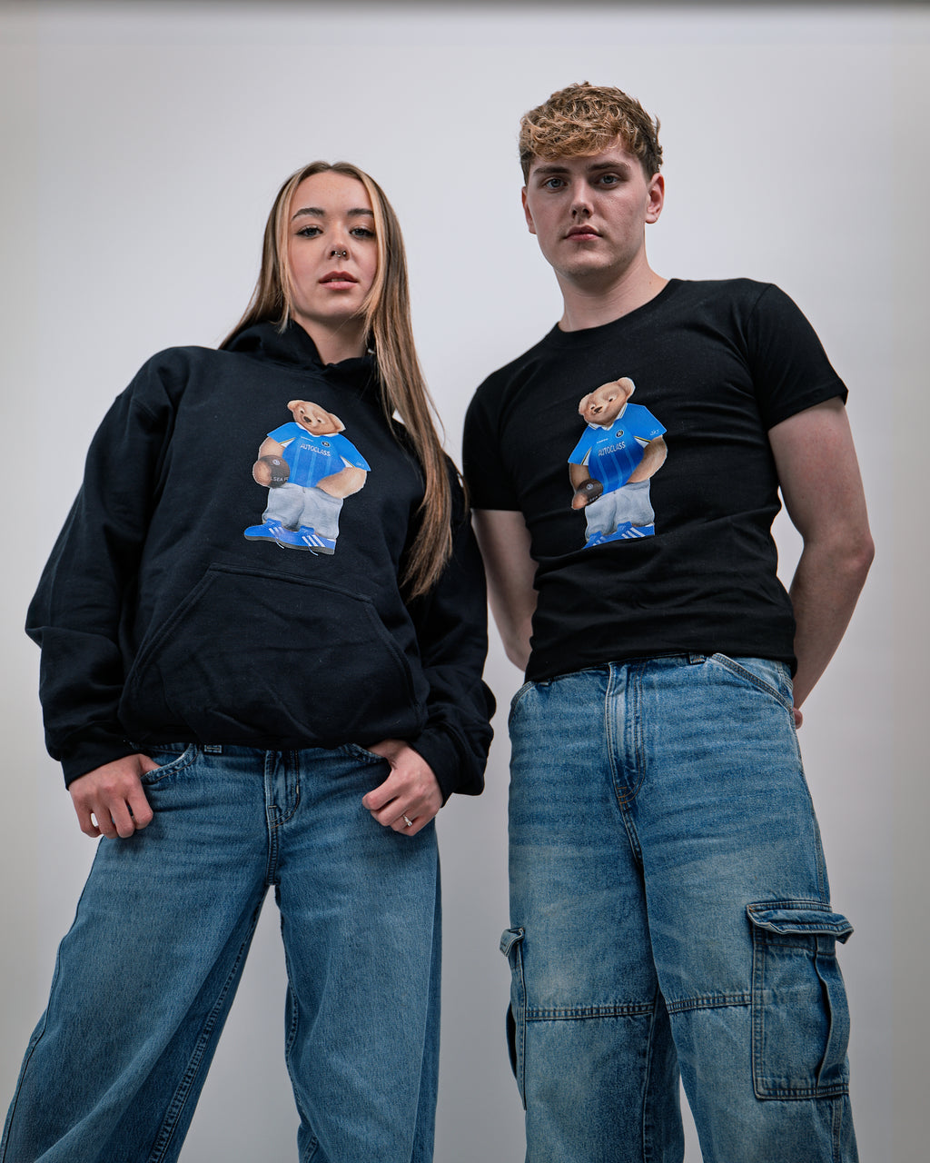Two people wearing black hoodies and t-shirts with a graphic of a person in a blue shirt and shorts.
