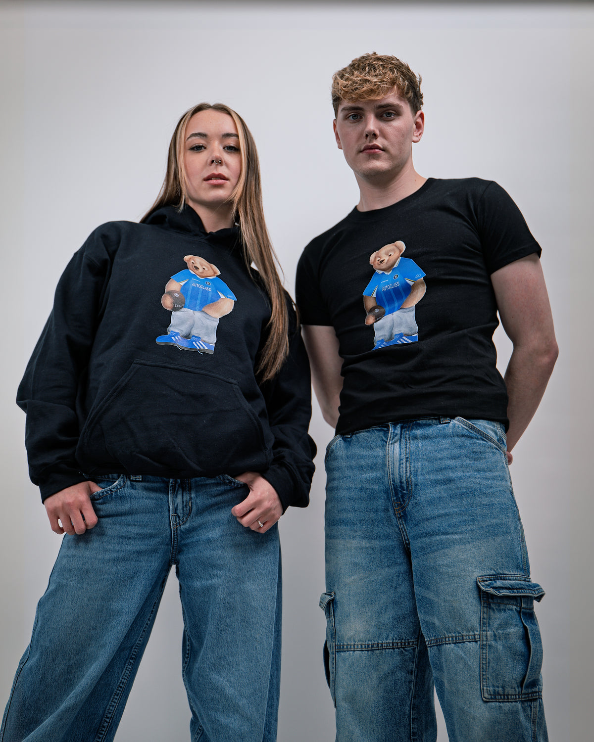 Two people wearing black hoodies and t-shirts with a graphic of a person in a blue shirt and shorts.