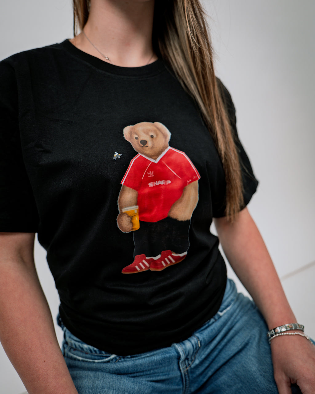 Person wearing a black t-shirt with a bear graphic in a red shirt and shorts.