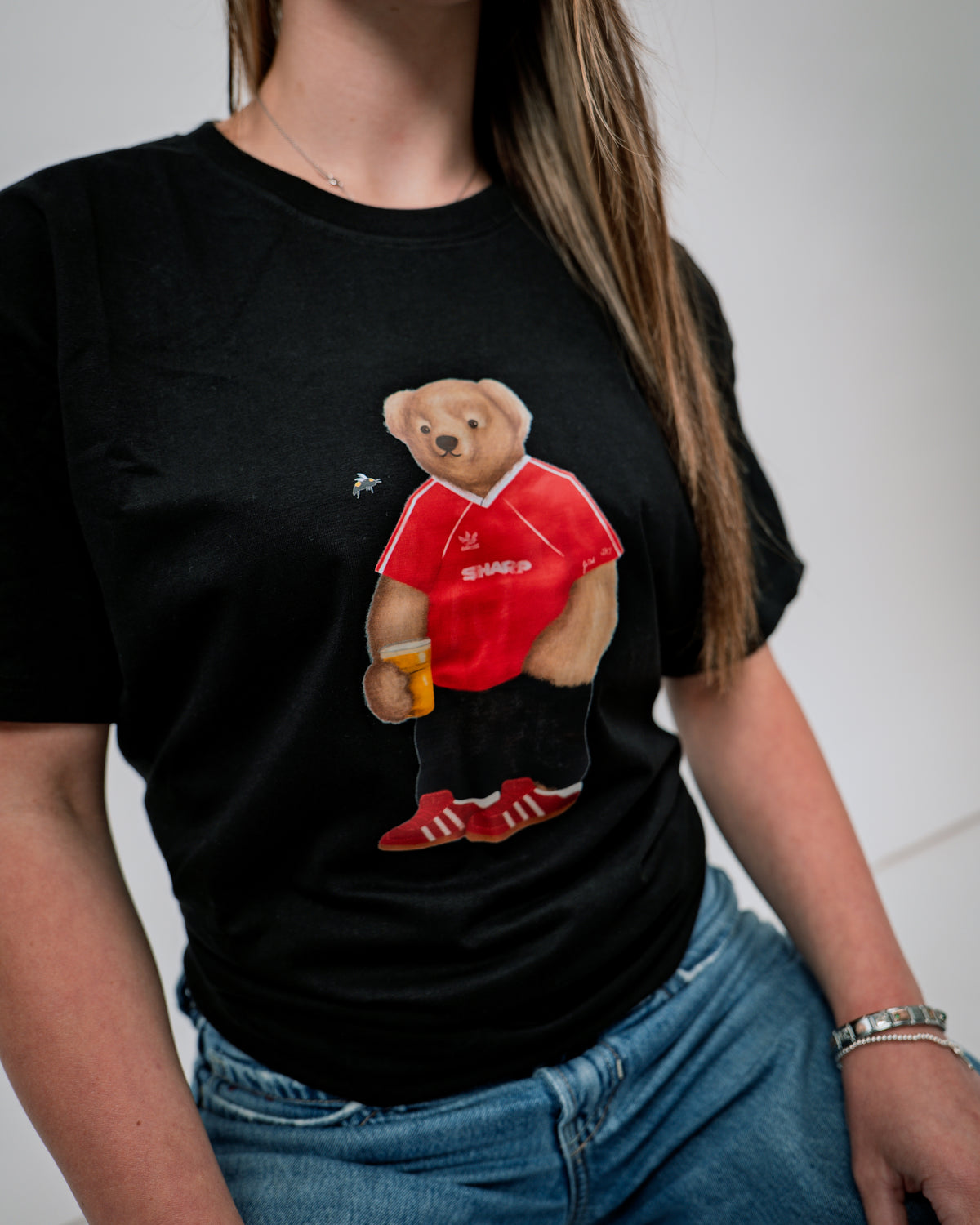Person wearing a black t-shirt with a bear graphic in a red shirt and shorts.