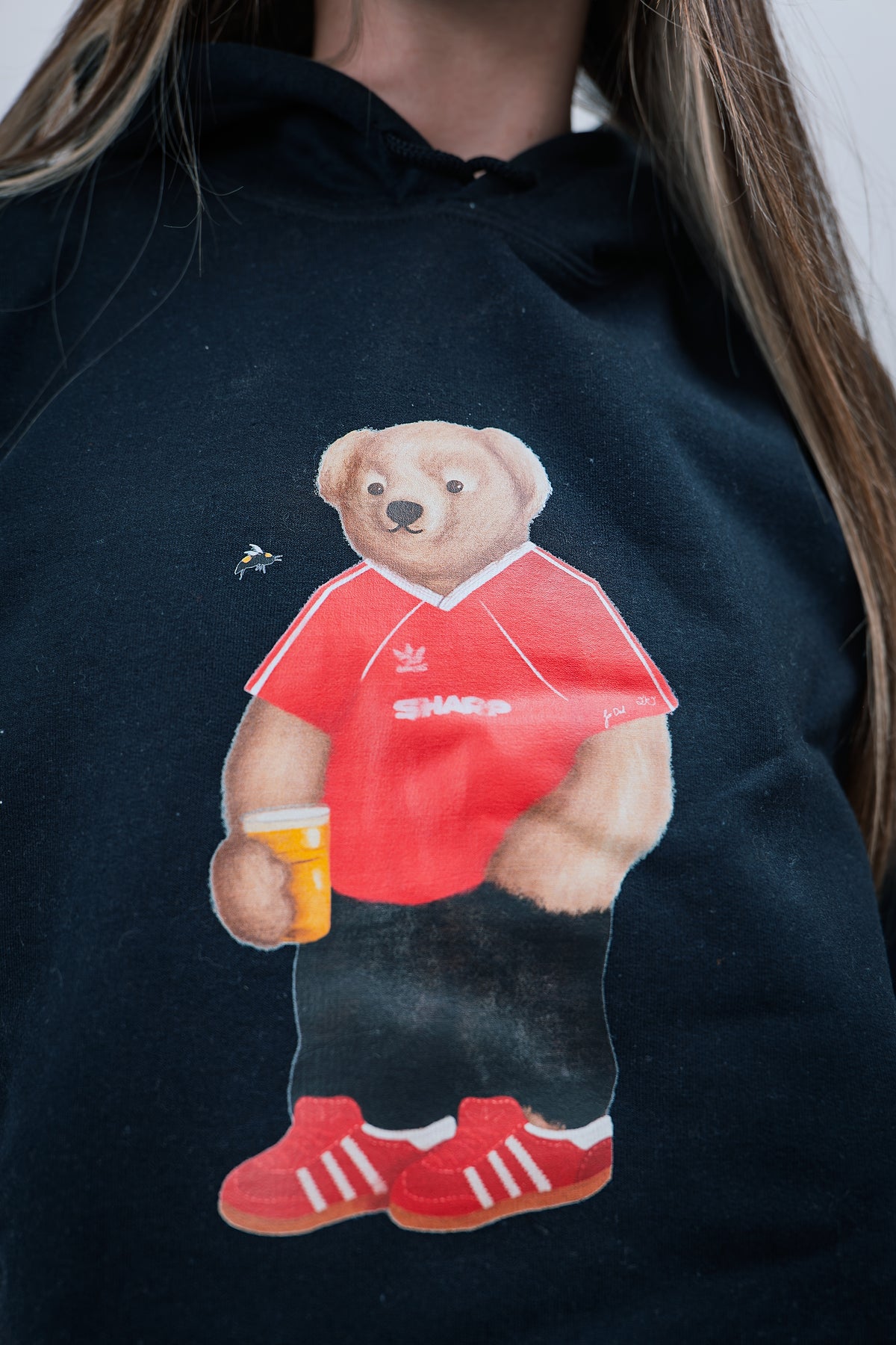 Black hoodie with a bear wearing a red shirt and holding a beer mug design.