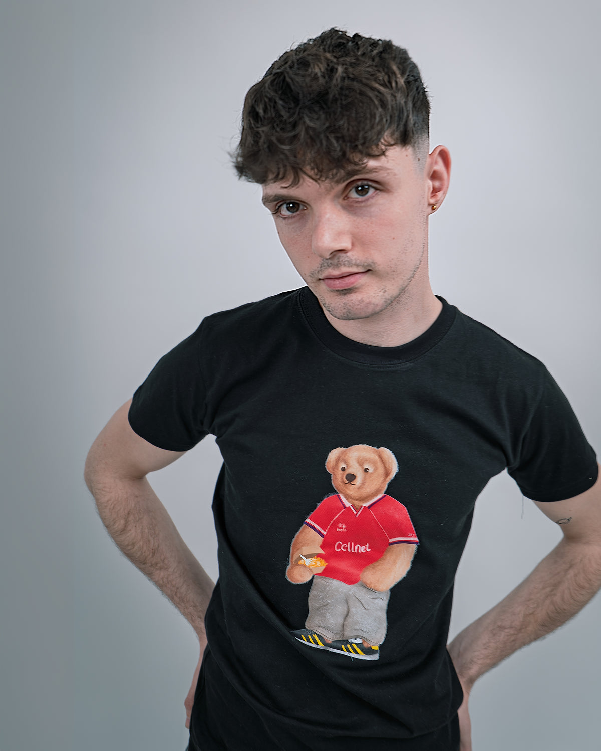 Person wearing a black t-shirt with a bear graphic in a red shirt on a gray background