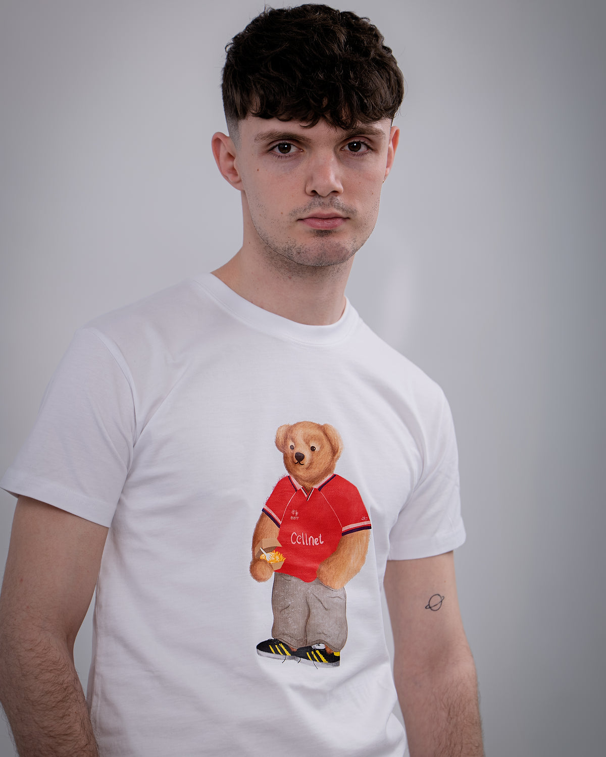 Person wearing a white t-shirt with a bear graphic in a red shirt on a gray background