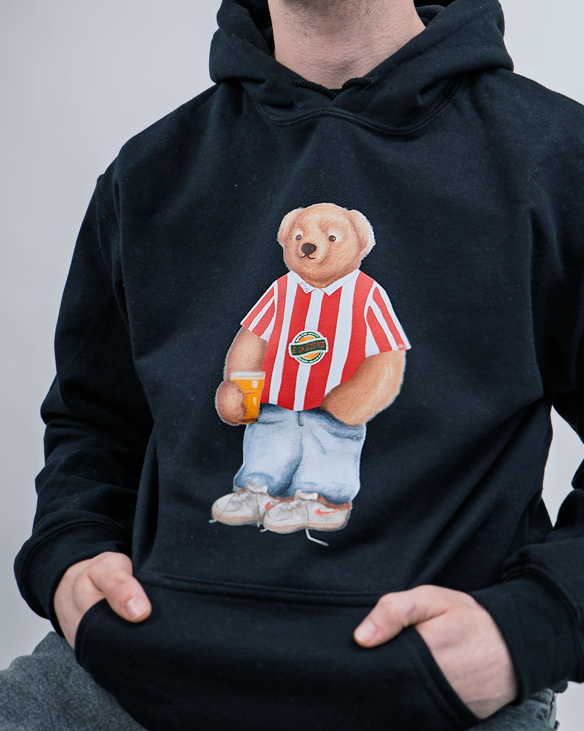 Black hoodie with a bear graphic holding a beer mug on a gray background