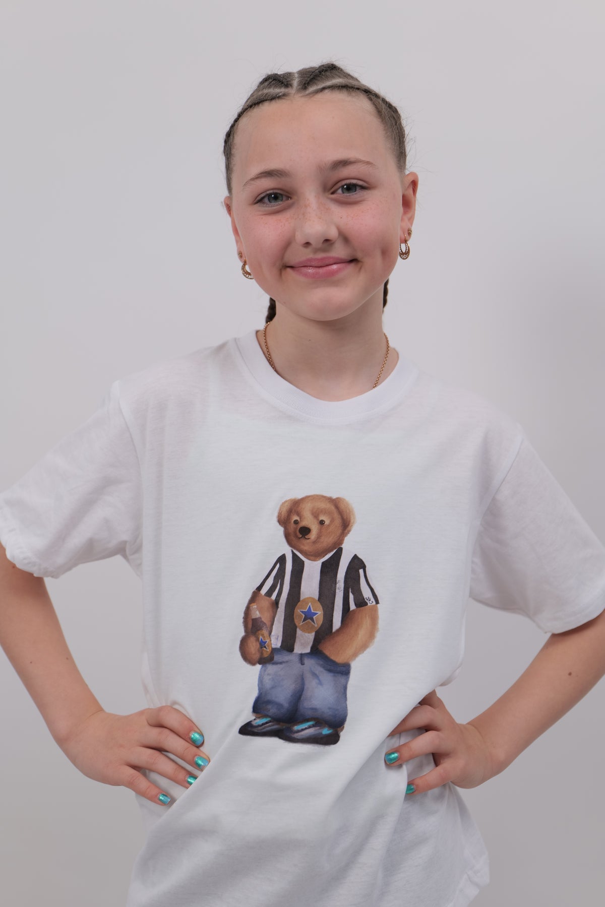 Person wearing a white t-shirt with a graphic design on a plain background