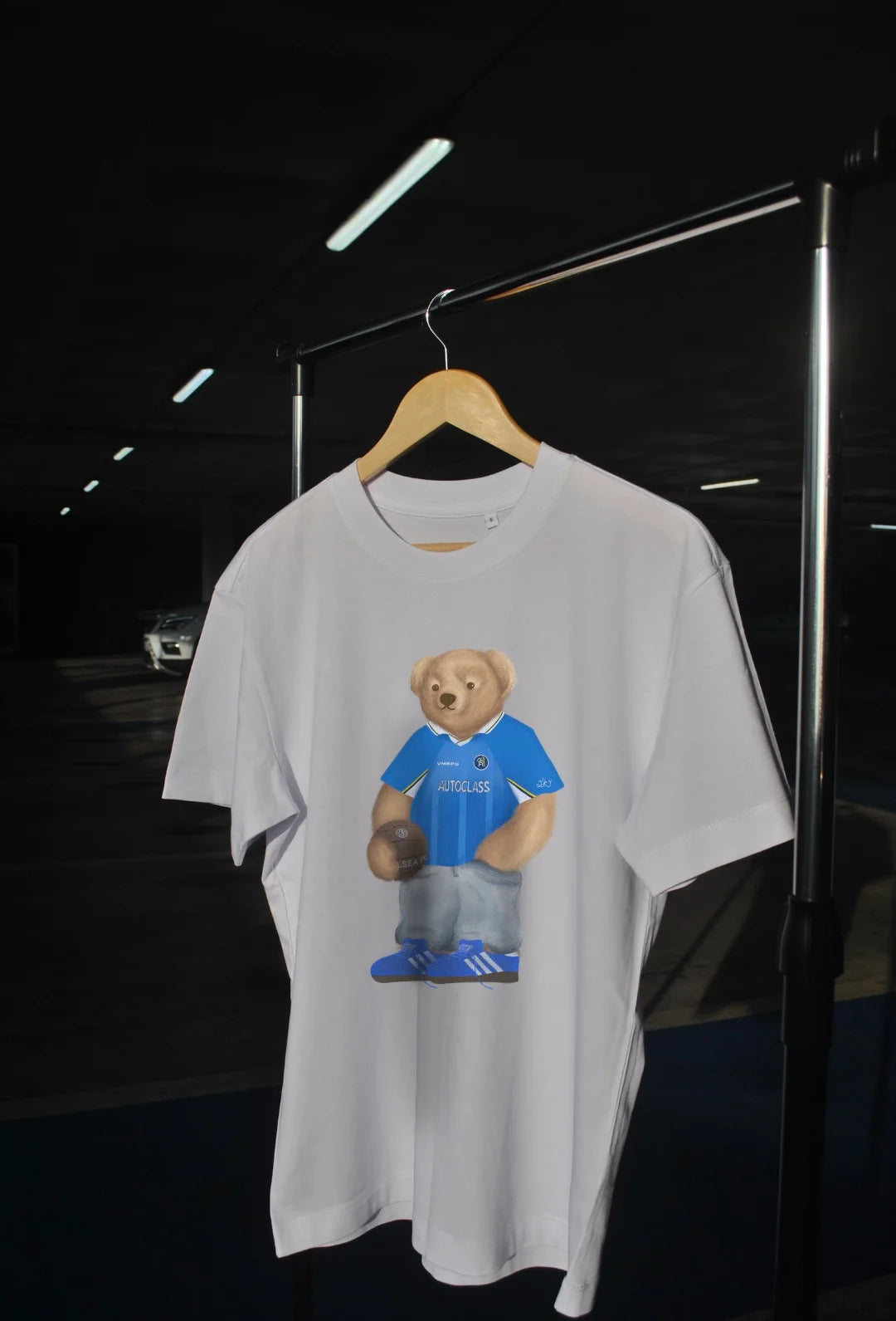 White t-shirt with a bear graphic wearing a blue jersey 