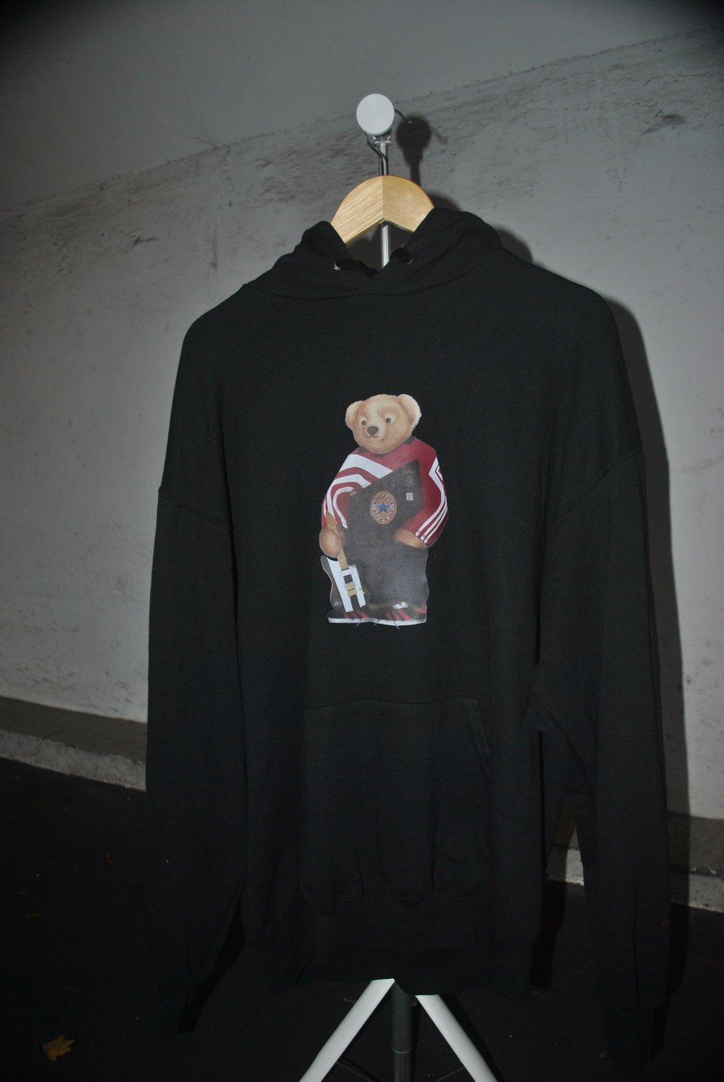 Black hoodie with a graphic design of a bear and text on a dark background