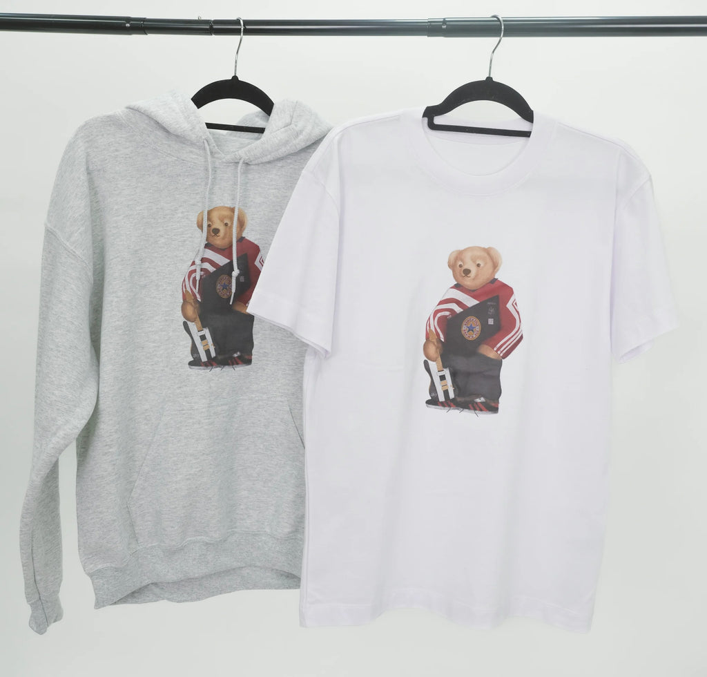 Gray hoodie and white t-shirt with bear graphic on hangers against a white background