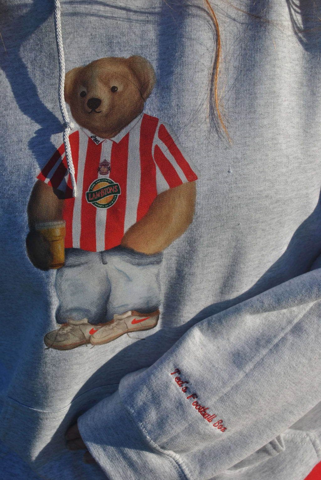 Teddy bear with a red and white striped shirt on a blue fabric background