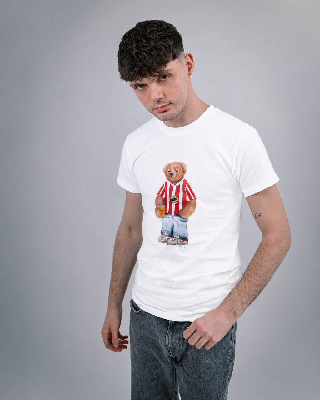Person wearing a white t-shirt with a graphic design on a gray background