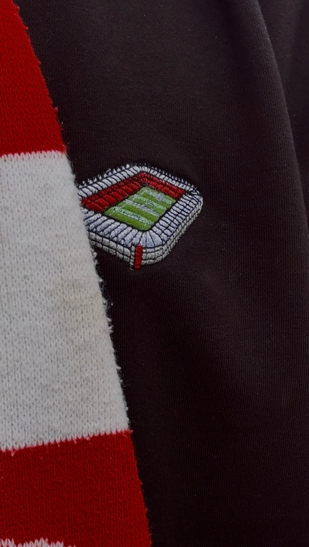 Close-up of a striped fabric with a embroidered emblem on a dark background